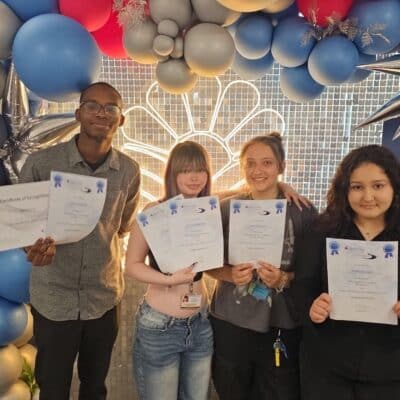 4 students holding certificates in celebration