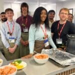 group of students standing in front of kitchen