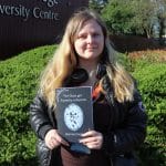 A student with blonde hair holding a poetry book