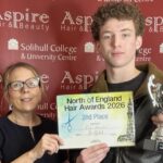 A student and a teacher holding a certificate.