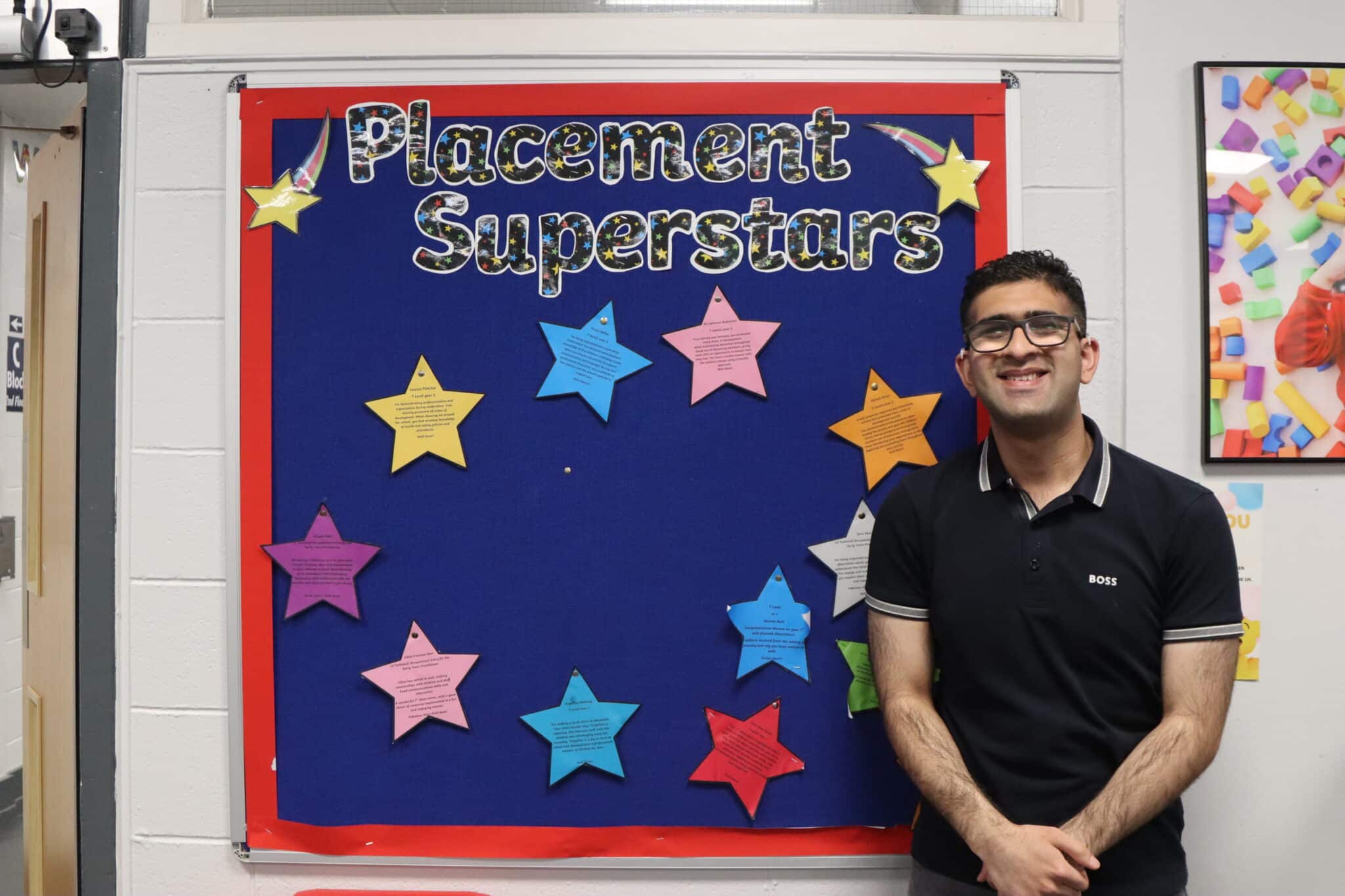 Shoaib standing in front of a sign saying 'Placement Superstars'