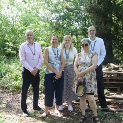 5 members off staff posing in a forest