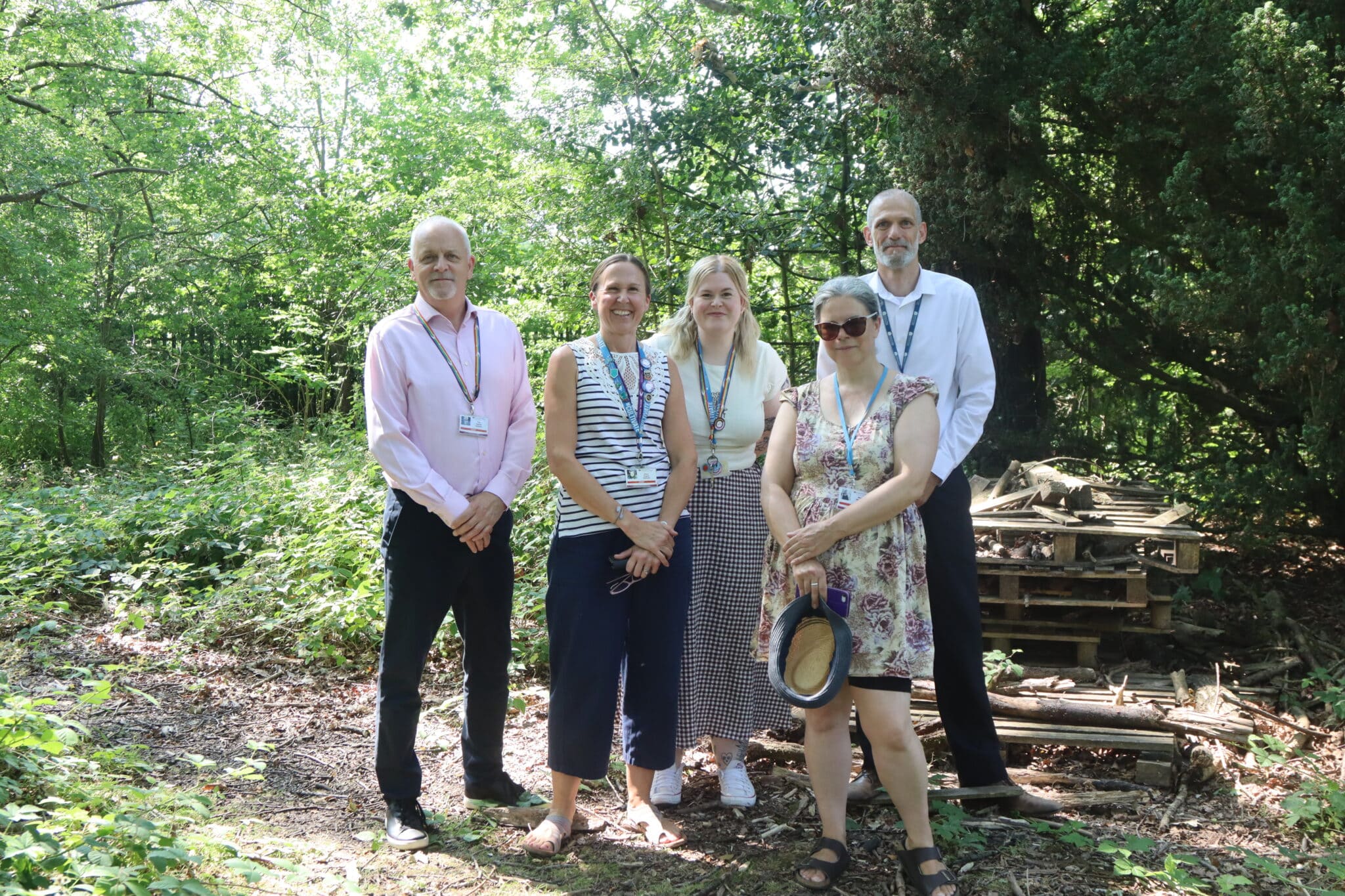 5 members off staff posing in a forest