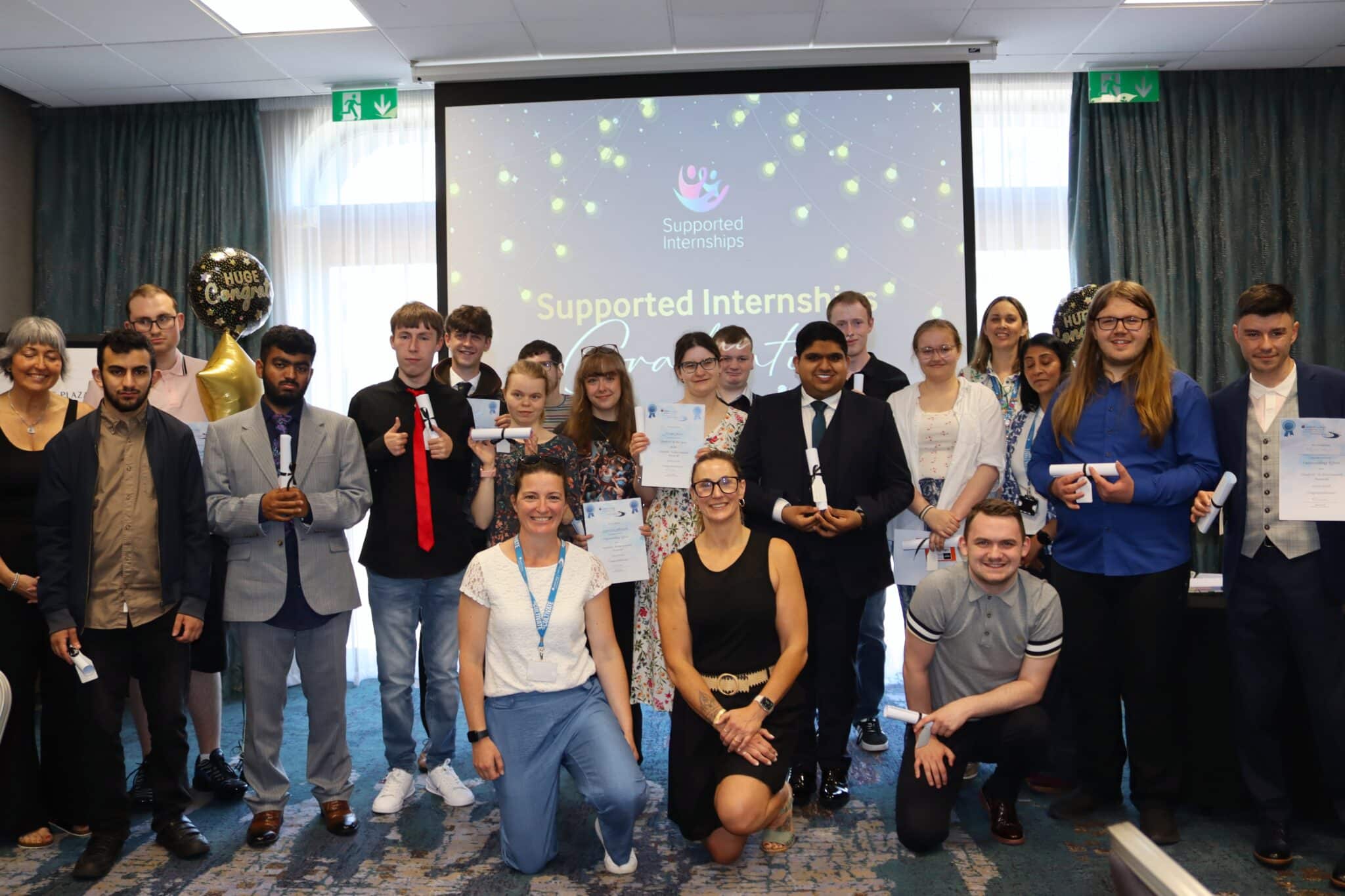 students and staff in front of a screen